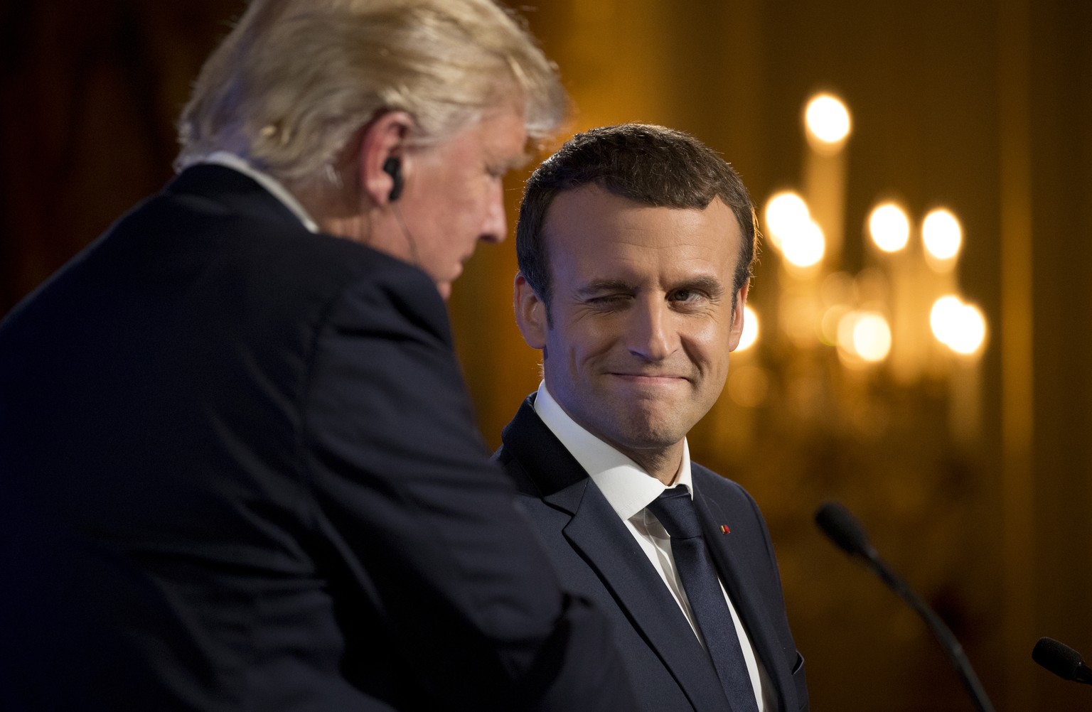 French President Emmanuel Macron winks at President Donald Trump during a joint news conference at the Elysee Palace in Paris, Thursday, July 13, 2017. (AP Photo/Carolyn Kaster)