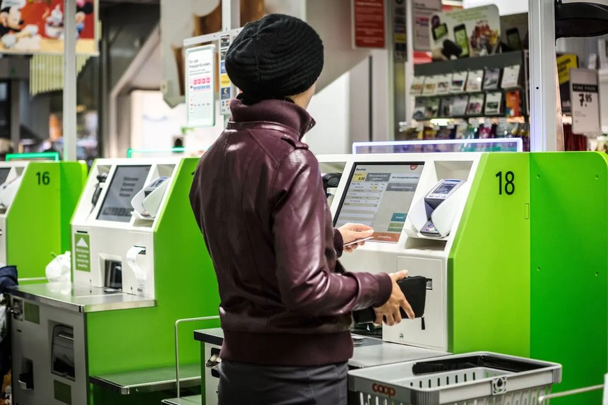 Eine Frau bezahlt bargeldlos in einer Coop-Filiale.