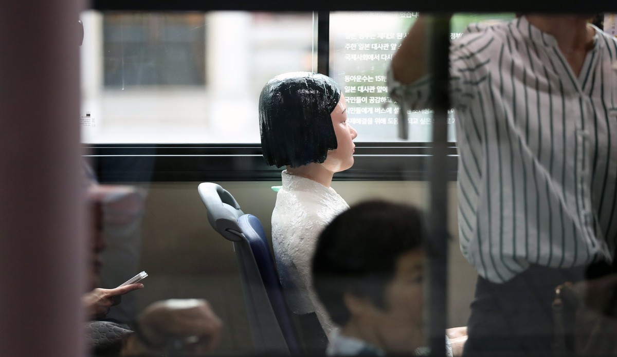 epa06143791 A 'comfort woman' statue is installed on a No. 151 line Seoul city bus in Seoul, South Korea, 14 August 2017, during the International Memorial Day for Comfort Women. Donga Bus C ...