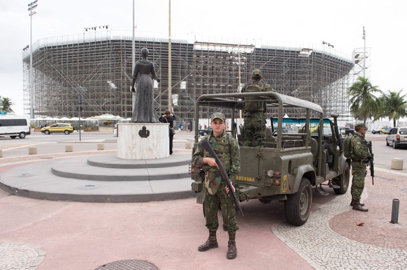 epa05445623 Security guards stand in front of a beach volleyball stadium surrounded by scaffolding on Copacabana beach in Rio de Janeiro, Brazil, 28 July 2016. The 2016 Olympic Games will take place i ...