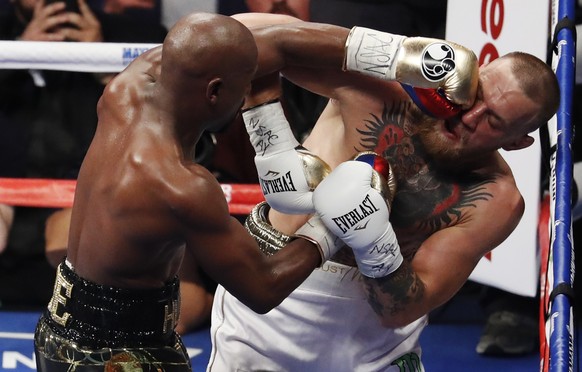 Floyd Mayweather Jr. hits Conor McGregor in a super welterweight boxing match Saturday, Aug. 26, 2017, in Las Vegas. (AP Photo/Eric Jamison)