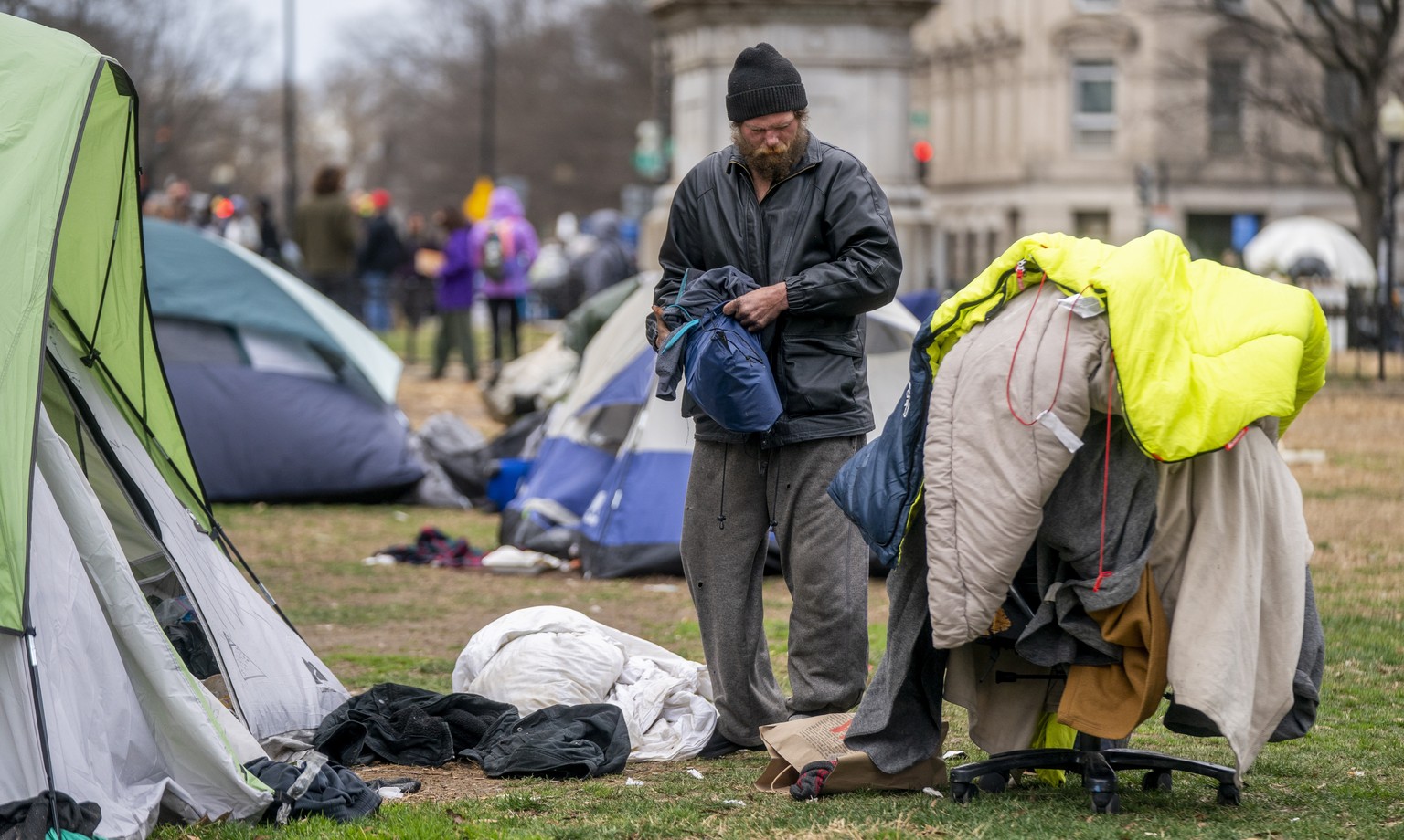 epa10468768 A homeless man packs his belongings before members of a National Park Service clean-up crew remove abandoned belongings from a homeless encampment at McPherson Square in Washington, DC, US ...