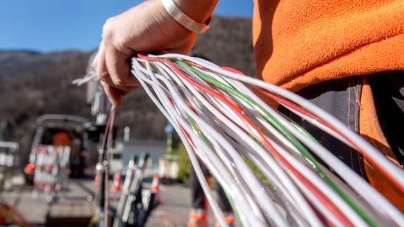 Ein Arbeiter montiert Glasfaserkabel der Swisscom fuer den Internetansschluss von Privathaushalten, am Dienstag, 10. Februar 2015 in Bellinzona. Die staedtischen Betriebe Bellinzona &quot;Aziende Muni ...
