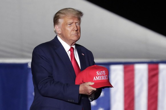 FILE - Former President Donald Trump tosses caps to the crowd as he holds a rally on Sept. 23, 2022, in Wilmington, N.C. The New York attorney general