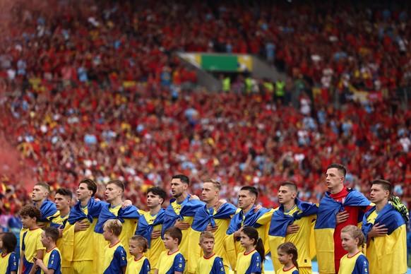 epa11439335 Players of Ukraine sing their national anthem ahead of the UEFA EURO 2024 Group E soccer match between Ukraine and Belgium, in Stuttgart, Germany, 25 June 2024. EPA/ANNA SZILAGYI