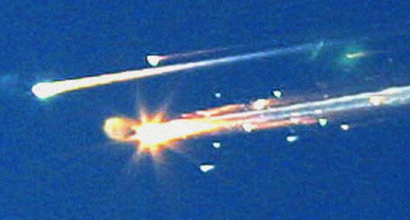 In this Saturday, Feb. 1, 2003 file photo, debris from the space shuttle Columbia streaks across the sky over Tyler, Texas. A new NASA report says that the seat restraints, suits and helmets of the do ...