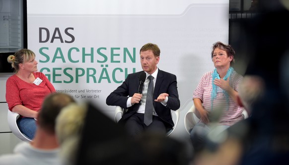 epa06984967 Saxony&#039;s Premier Michael Kretschmer (C) speaks to visitors at the stadium of Chemnitz FC soccer club in Chemnitz, Germany, 30 August 2018. The Premier of Saxony invited citizens to a  ...