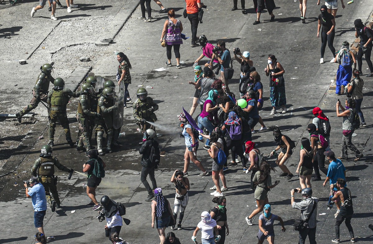 Women clash with the police near La Moneda presidential palace during a protest marking International Women's Day, in Santiago, Chile, Sunday, March 8, 2020. (AP Photo/Esteban Felix)