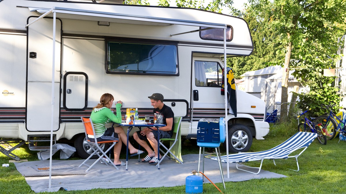 Two young people sit in front of their camper, pictured on the campground &amp;quot;Seeland&amp;quot; in Sempach in the canton of Lucerne, Switzerland on July 23, 2008. (KEYSTONE/Martin Ruetschi)

Zwe ...