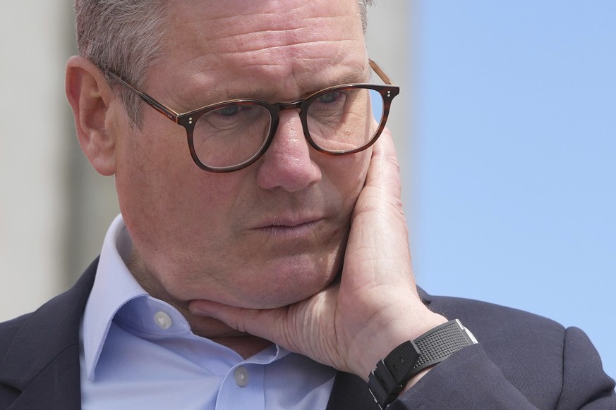 FILE - Labour Party leader Keir Starmer listens to a question from port workers during a general election campaign event Southampton Docks in Southampton, England, Monday, June 17, 2024. The United Ki ...