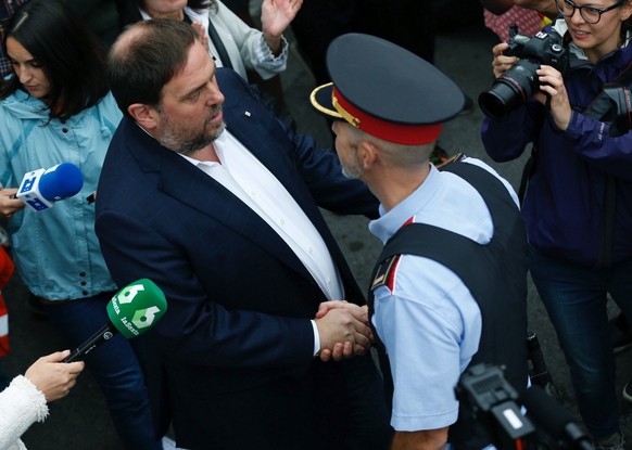 epa06237401 Catalan Deputy Premier, Oriol Junqueras (L), greets a Catalan policeman or Mosso d&#039;Esquadra as he arrives to the Sant Jordi School to vote in the &#039;1-O Referendum&#039; in Sant Vi ...