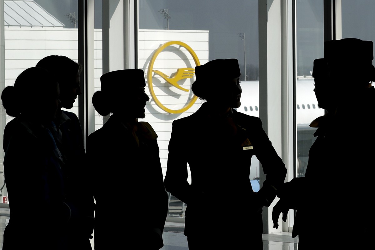 FILE - In this Thursday, March 16, 2017 file photo Lufthansa flight attendants silhouetted as they pose for a photograph on occasion of the company's annual press conference in Munich, Germany. L ...