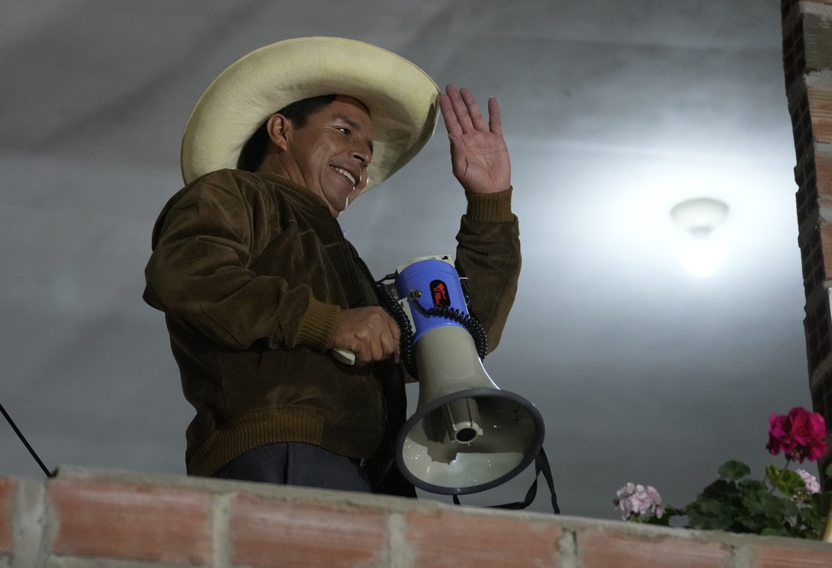 Presidential candidate Pedro Castillo waves from a balcony of his part headquarters before talking to his supporters during a runoff election, in Tacabamba, Peru, Sunday, June 6, 2021. Peruvians voted ...