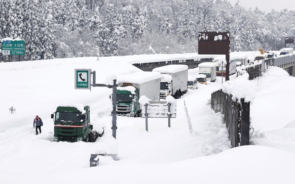 Vehicles are stranded in the snow on an express way in Muikamachi, Niigata prefecture, northern Japan, Friday, Dec. 18, 2020. Heavy snow hit areas of northern Japan on Thursday, causing several hundre ...