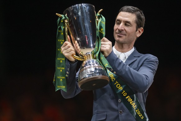 Steve Guerdat from Switzerland celebrates with the trophy after winning the 22th IJRC top 10 final at the 62th CHI international horse show jumping tournament in Geneva, Switzerland, on Friday, Decemb ...