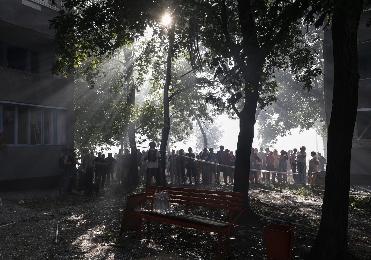 epa11574013 Locals stand behind a cordon near the site of a damaged 12-story residential building following a missile strike in Kharkiv, northeastern Ukraine, 30 August 2024, amid the Russian invasion ...