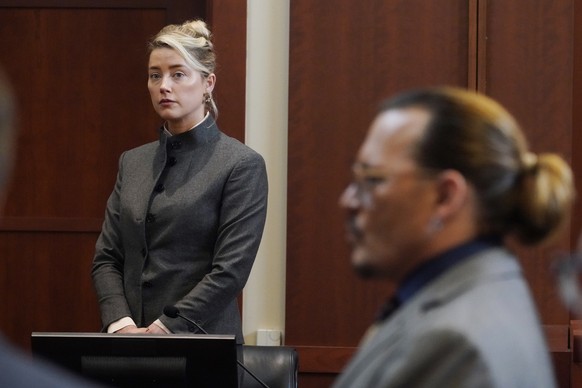 FILE - Actors Amber Heard and Johnny Depp watch as the jury leaves the courtroom for a lunch break at the Fairfax County Circuit Courthouse in Fairfax, Va., Monday, May 16, 2022. Heard notified a Virg ...