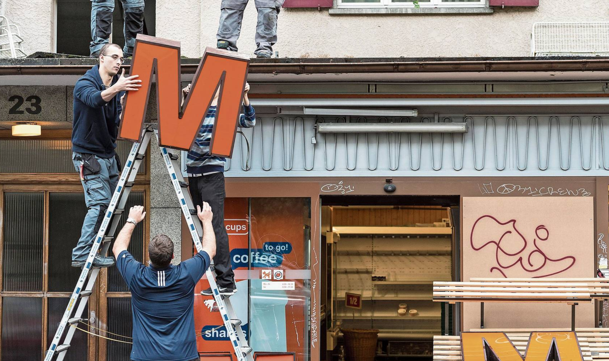 Die Migros muss sich anpassen: Arbeiter demontieren das grosse «M» auf dem Dach einer Filiale.