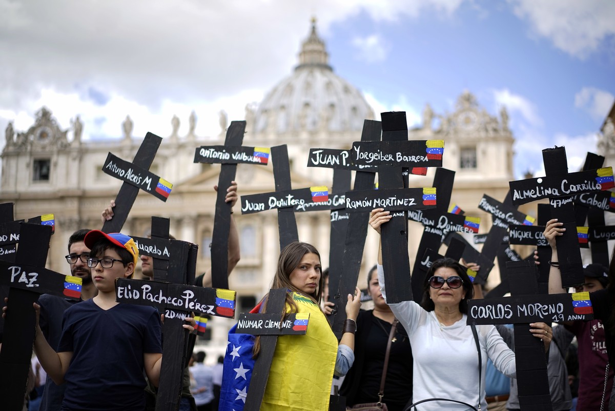 Demonstrators hold black crosses adorned with Venezuela flags and with the names of those who were killed in weeks of violent demonstrations calling on Venezuela's President Nicolas Maduro to ste ...