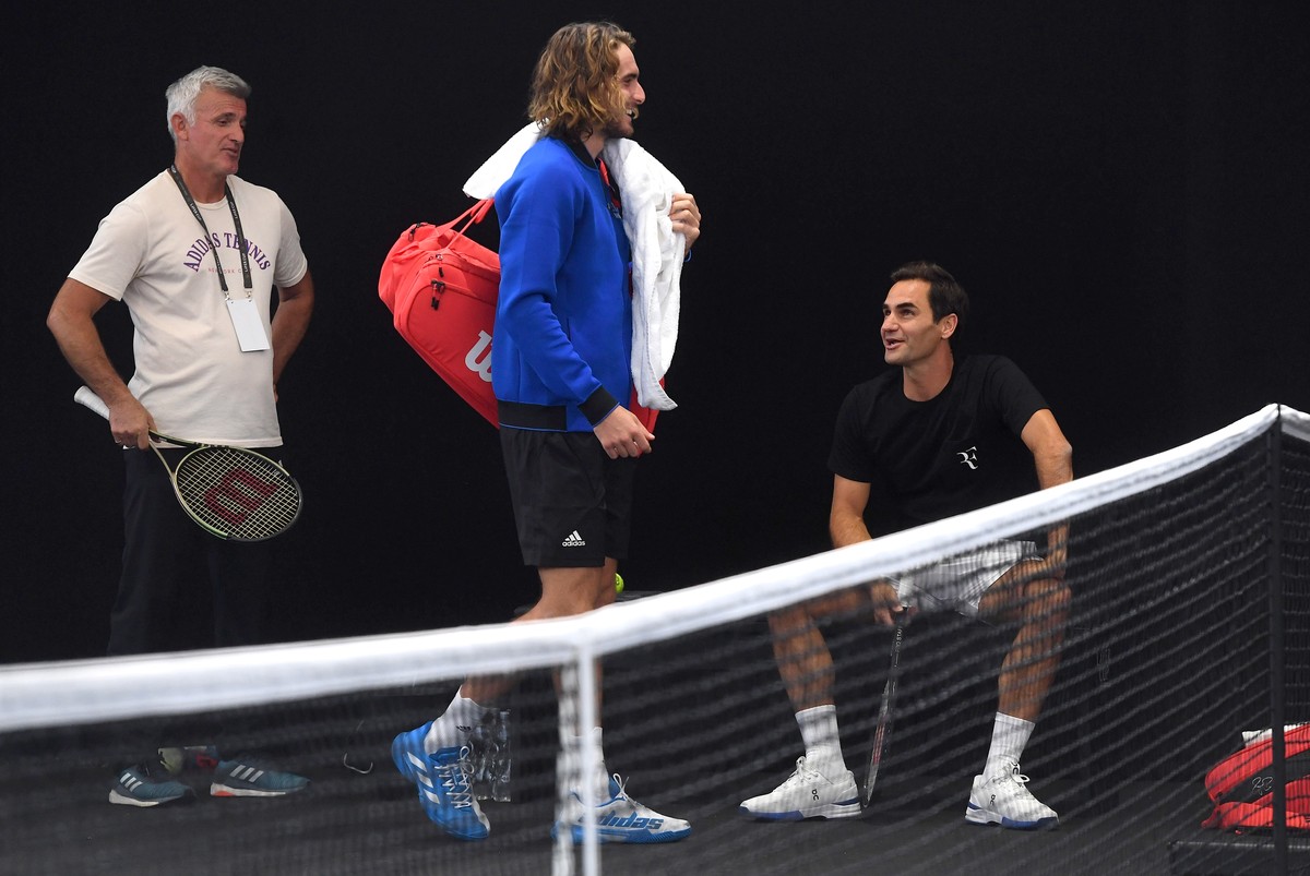 epa10196985 Roger Federer (R) of Switzerland speaks to Greek player Stefanos Tsitsipas, accommpanied by his father Apostolos Tsitsipas (L), during a practice session in London, Britain, 21 September 2 ...