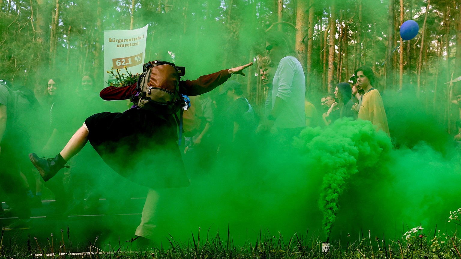 epaselect epa11333151 Environmental activists are shrouded in flare smoke during a protest against Tesla&#039;s plans to extend its Gigafactory plant, in Gruenheide, near Berlin, Germany, 11 May 2024. ...