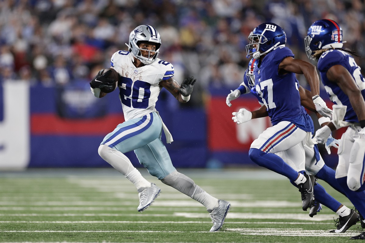 Dallas Cowboys' Tony Pollard, left, runs the ball during the second half of an NFL football game against the New York Giants, Sunday, Sept. 10, 2023, in East Rutherford, N.J. (AP Photo/Adam Hunge ...