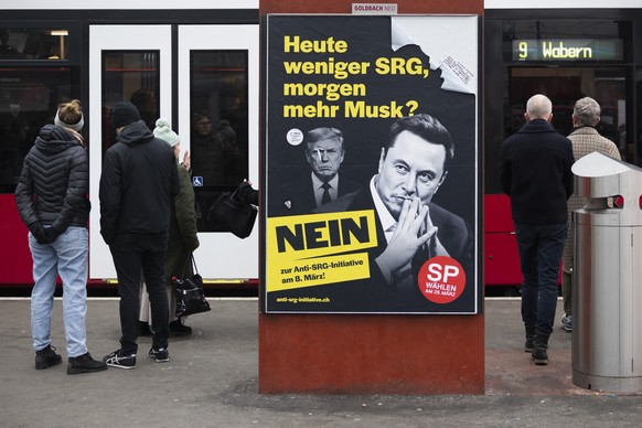 Ein Plakat mit den Koepfen von Elon Musk und Donald Trump wirbt fuer ein Nein zur Anti-SRG-Initiative (Halbierungsinitiative), am Sonntag, 18. Januar 2026 bei der Tramstation auf dem Bahnhofplatz in B ...