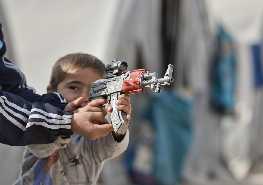 Syrian Kurdish refugee children from the Kobani area, play with a toy gun at a camp in Suruc, on the Turkey-Syria border Thursday, Nov. 13, 2014. Kobani, also known as Ayn Arab, and its surrounding ar ...