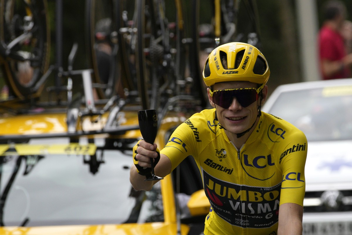 Denmark's Jonas Vingegaard, wearing the overall leader's yellow jersey, toasts champagne during the twenty-first stage of the Tour de France cycling race over 115 kilometers (71.5 miles) wit ...