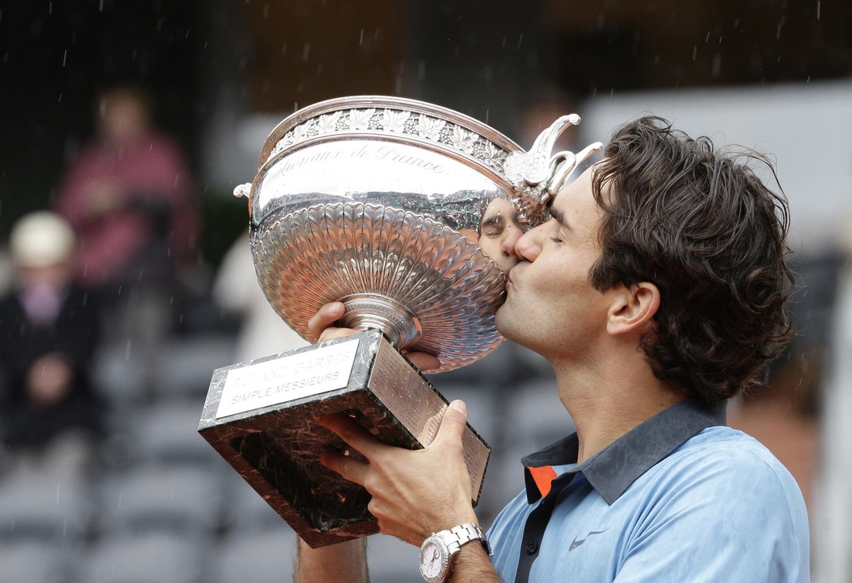 Switzerland's Roger Federer kisses the trophy after defeating Sweden's Robin Soderling during their men's singles final match of the French Open tennis tournament at the Roland Garros s ...