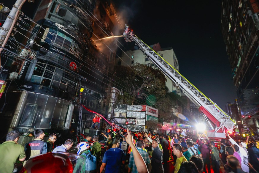 epa11189663 Bangladeshi firefighters try to douse the fire after flames erupted at a building in Dhaka, Bangladesh, late 29 February 2024. At least 43 people have died after a fire engulfed a commerci ...