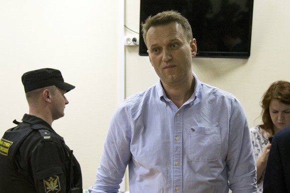 Russian opposition leader Alexei Navalny, center, attends a hearing in a court in Moscow, Russia, Tuesday, June 13, 2017. A Moscow court has ruled that Alexei Navalny should be jailed for 30 days for  ...