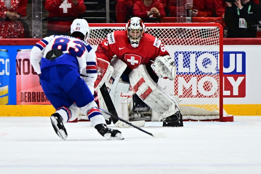 epa12135343 Switzerland's goalkeeper Leonardo Genoni (#63) saves a penalty shot from USA's Conor Garland (#83) during the IIHF Ice Hockey World Championship final match between Switzerland a ...