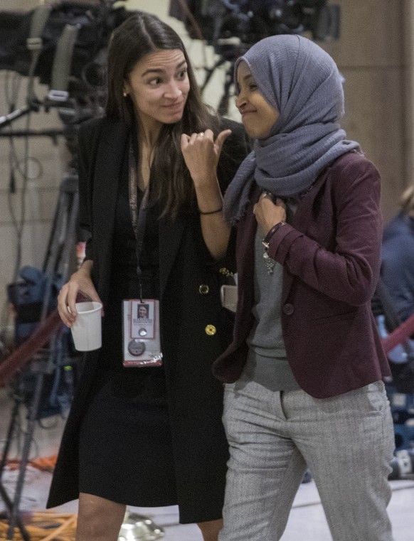 epa07167605 Incoming Democratic House of Representative members Alexandria Ocasio-Cortez (L) of New York and Ilhan Omar (R) of Minnesota walk to new member orientation at the US Capitol in Washington, ...