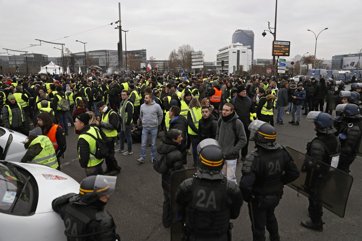 epa07253165 Protesters are blocked by the French riot police in front of the French notional television building during a 'Yellow Vests' protest in Paris, France, 29 December 2018. The so-ca ...