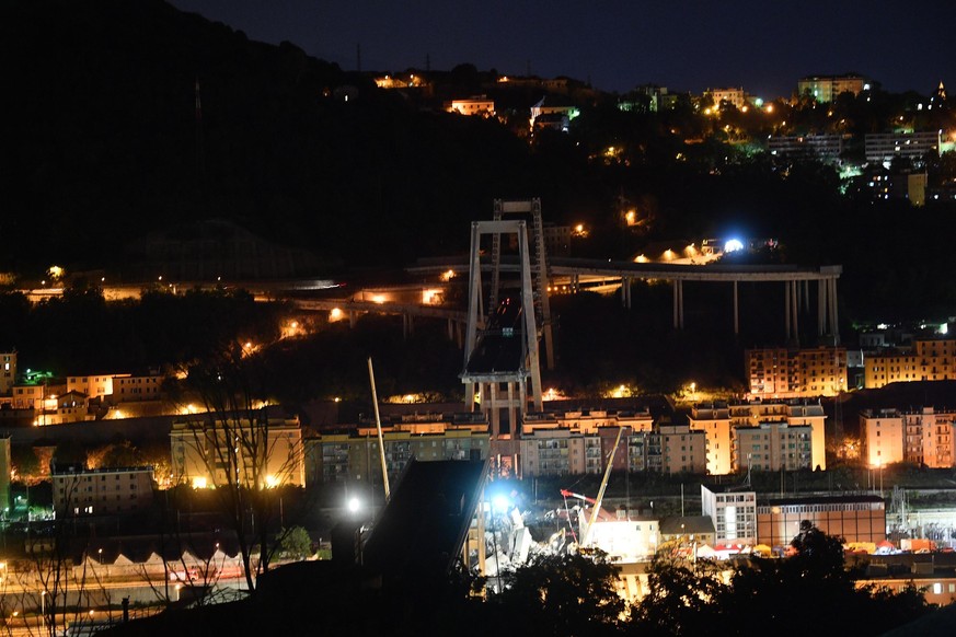 epa06952164 Night view of the Morandi bridge collapsed in Genoa, Italy, 15 August 2018 (issued on 16 August 2018). People living in the buildings in the area have been evacuated following the collapse ...