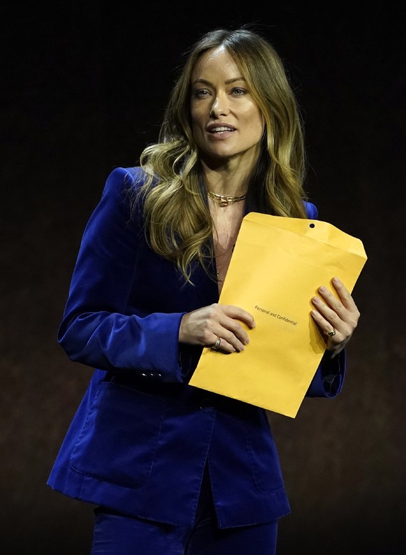 Olivia Wilde, director of the upcoming film &quot;Don&#039;t Worry Darling,&quot; holds an envelope that was handed to her onstage during the Warner Bros. Pictures presentation at CinemaCon 2022 at Ca ...