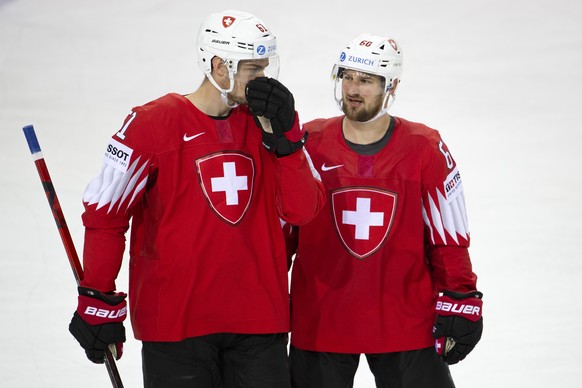 Switzerland&#039;s forward Fabrice Herzog, left, talks to teammate forward Tristan Scherwey, right, during the IIHF 2021 World Championship preliminary round game between Switzerland and Slovakia, at  ...