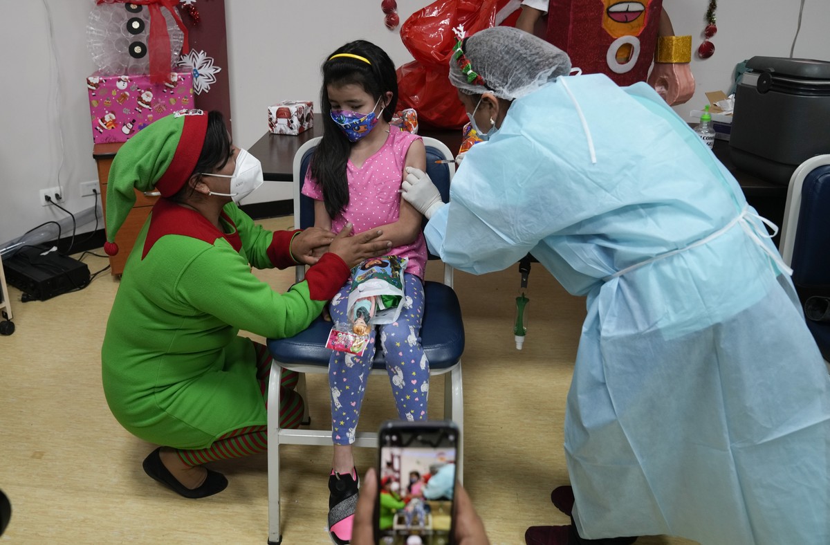 A child gets a dose of the Sinopharm COVID-19 vaccine during a campaign targeting children between ages 5 and 11 at La Portada Hospital where some health workers dressed up in Christmas costumes in La ...