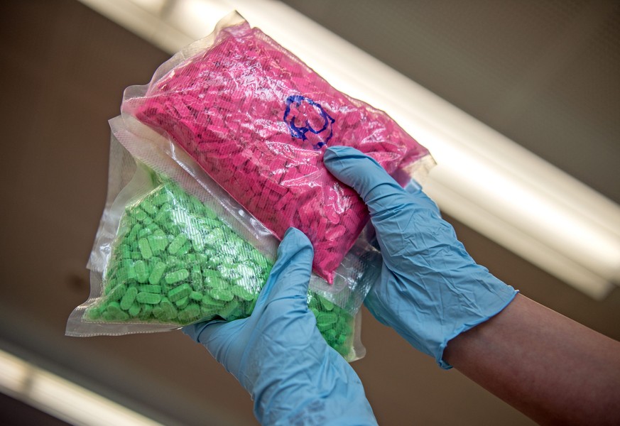 epa05187385 A member of the German Federal Criminal Police Office (BKA) holds up two plastic bags of Ecstasy pills, in Wiesbaden, Germany, 29 February 2016. Several pieces of evidence were seized and  ...