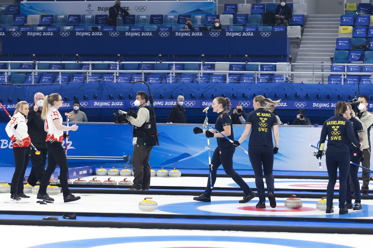 Sweden's players celebrate in front of Switzerland skip Silvana Tirinzoni, left, and Switzerland's Alina Paetz, 2nd eft, after defeating Switzerland team during the women's curling bron ...