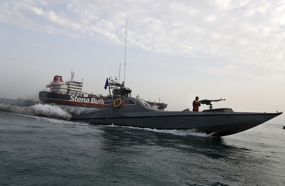 FILE- In this July 21, 2019, file photo, a speedboat of the Iran&#039;s Revolutionary Guard moves around a British-flagged oil tanker Stena Impero, which was seized by the Guard, in the Iranian port o ...