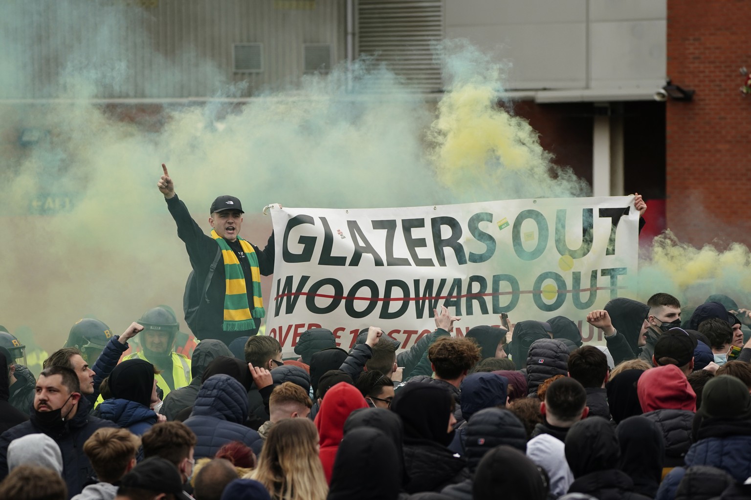 Manchester United fans let off flares and hold a banner as they protest against the Glazer family, the American owners of Manchester United, before their English Premier League soccer match against Li ...