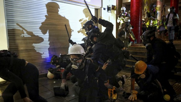 Policemen charge towards protesters during the anti-extradition bill protest at Tsim Sha Tsui in Hong Kong, Sunday, Aug. 11, 2019. Police fired tear gas late Sunday afternoon to try to disperse a demo ...