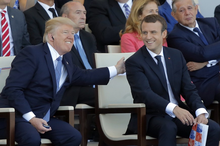 FILE - In this July 14, 2017, file photo, French President Emmanuel Macron, right, and U.S. President Donald Trump attending the traditional Bastille Day military parade on the Champs Elysees, in Pari ...