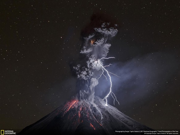 Der Vulkan Colima in Mexiko stösst eine mächtige Aschewolke aus, glühende Lava fliesst hinunter und wäre das nicht schon genug Spektakel schlägt noch ein Blitz ein. Für sein Foto hat Sergio Tapiro Vel ...