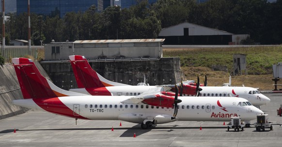FILE - In this March 17, 2020 file photo, aircraft from the Avianca airline sit parked at La Aurora airport in Guatemala City. Avianca