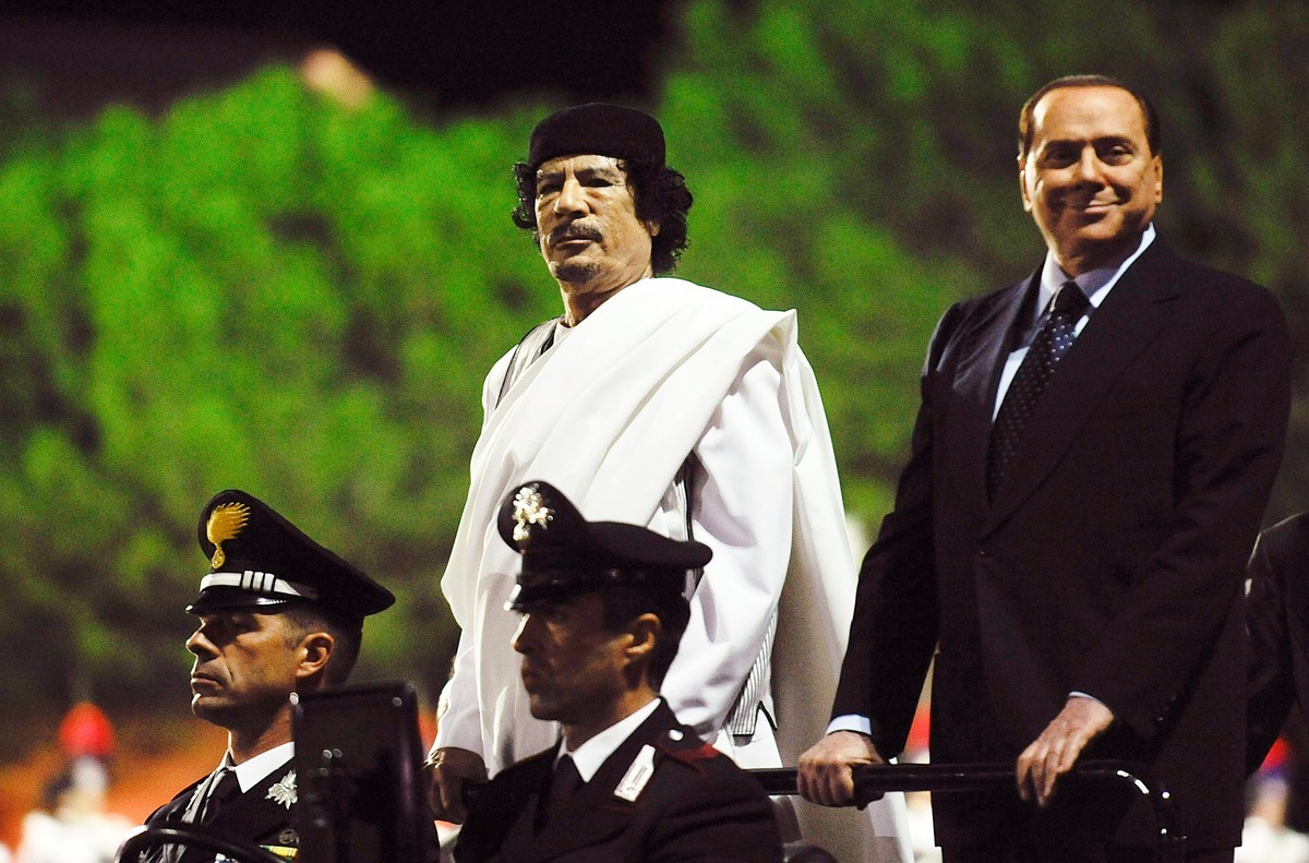 ROME - AUGUST 30: Libyan leader Muammar Gaddafi (L) and Italian Prime Minister Silvio Berlusconi (R) arrive at a ceremony for the Italia - Libya friendship day at Salvo D'Acquisto barracks, on Au ...