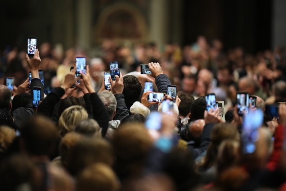 People take photos of Pope Leo XIV as he arrives to celebrate Mass on the Day of the Epiphany of the Lord inside St. Peter's Basilica at the Vatican, Tuesday, Jan. 6, 2026. (AP Photo/Alessandra T ...