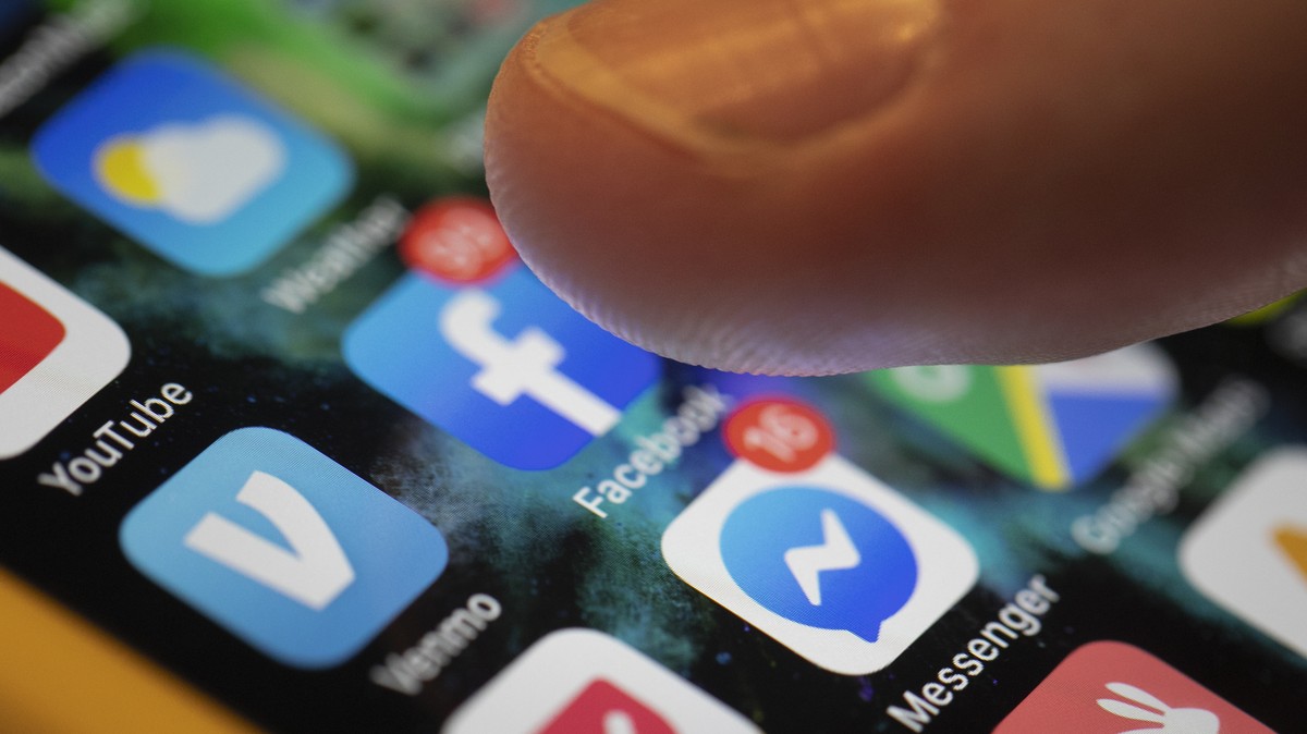 FILE - In this Aug. 11, 2019, file photo an iPhone displays the apps for Facebook and Messenger in New Orleans. Facebook says the U.S. Department of Homeland Security will be violating the company ...